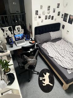 a bedroom with mickey mouse decorations on the wall and a bed in the corner, next to a laptop computer