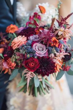 a bride and groom holding a bouquet of flowers