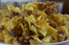 a white plate topped with pasta and meat