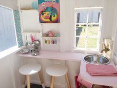 two stools sit in front of a pink counter