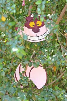 a paper cat hanging from a tree branch