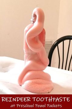 a pink toothbrush holder sitting on top of a bed