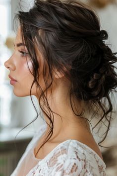 a woman with dark hair is wearing a white top and looking off to the side