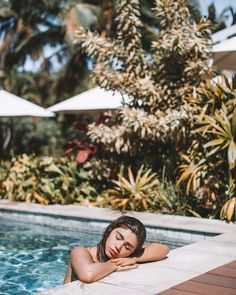 a woman laying on the edge of a swimming pool