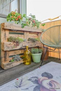 a wooden pallet filled with plants on top of a patio