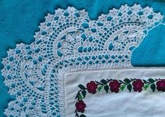 two pieces of white lace with red flowers on them