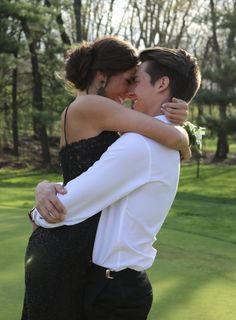 two people hugging each other on a golf course