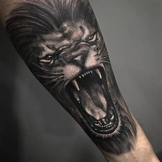 a man's arm with a black and white tattoo of a lion on it