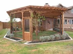 a wooden gazebo sitting on top of a lush green field