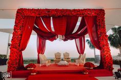 a red and white wedding set up with flowers