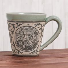 a green coffee cup sitting on top of a wooden table