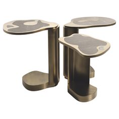 two metal tables with designs on them, one is black and the other is gold