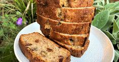 slices of banana bread stacked on top of each other on a plate in front of some flowers