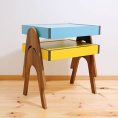 a desk made out of wood and painted blue, yellow, and green with a wooden legs