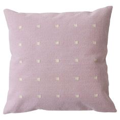 a pink pillow with white dots on it