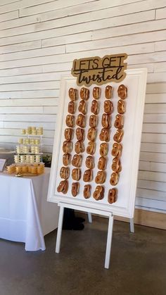 a sign with donuts on it sitting next to a table filled with drinks and desserts