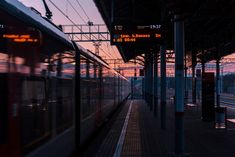 a train is pulling into the station at sunset