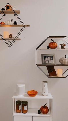 two shelves with pumpkins, candles and other items on them in the shape of hexagonal shapes