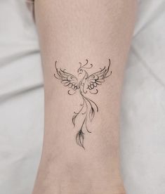 a woman's foot with a bird tattoo on the left side of her leg