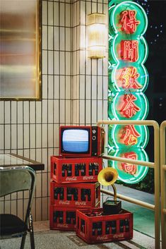 three red boxes stacked on top of each other in front of a neon sign with chinese writing