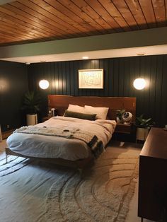 a large bed sitting in the middle of a room with two lamps on either side of it