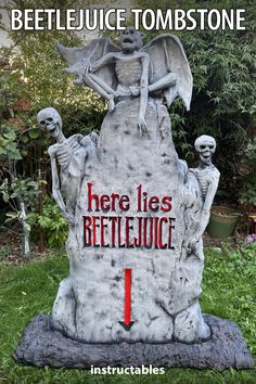 there is a fake skeleton sitting on top of a tombstone with the words here lies beetlejuice