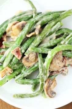 green beans and mushrooms on a white plate