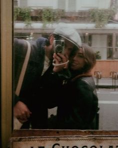 a man and woman taking a selfie in front of a sign that says le chosson