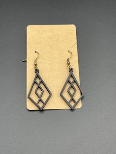 a pair of black earrings sitting on top of a piece of paper next to each other