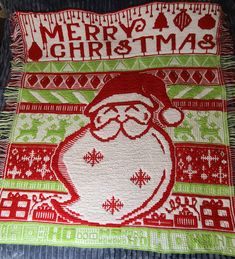 a knitted christmas blanket with santa clause on it