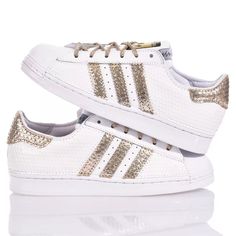 Adidas Superstar White Hive is the super glamorous custom women's sneaker. Entirely in white eco-leather with a geometric texture, featuring the iconic adidas stripes and a textured gold laminated back paired with round gold lurex laces. Adidas Superstar White Hive will also be provided with its original laces. Gold Sneakers With Foil Embossed Logo And Round Toe, Sporty Gold Sneakers With Perforations, White Leather Sneakers With Foil Embossed Logo, Gold Low-top Sneakers With Perforations, Geometric Texture, Zegna Shoes, Sneaker Wedge, Custom Shoes, Manolo Blahnik