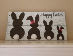 a wooden sign with three rabbits painted on it's sides and the words happy easter