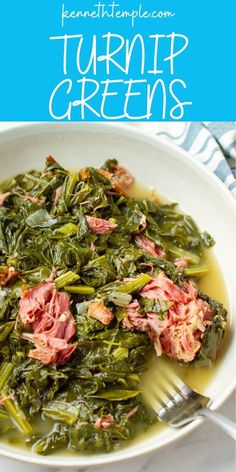 a white bowl filled with greens and meat on top of a blue and white table cloth