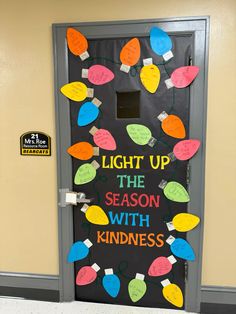 a door decorated with christmas lights and the words light up the season with kindness