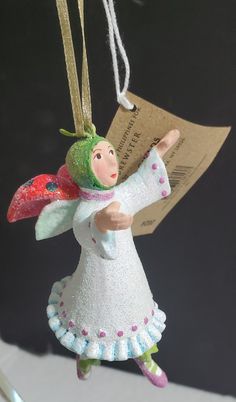 a christmas ornament with an angel holding a piece of paper