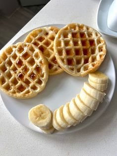 some waffles and bananas on a white plate