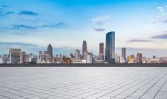 an empty parking lot with the city skyline in the background