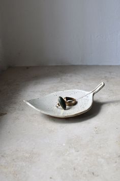 a white plate with two rings on it sitting on the floor next to a wall