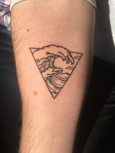 a man's arm with a tattoo on it that has a wave coming out of the ocean