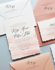 the wedding stationery is laid out on top of each other, including pink and white envelopes