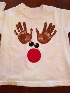 a white t - shirt with handprints on it that has a red nose