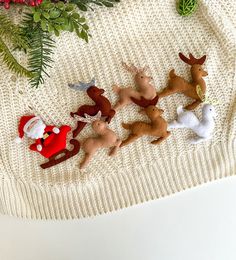 christmas ornaments are laid out on a knitted surface