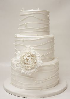 a white wedding cake with flowers on top