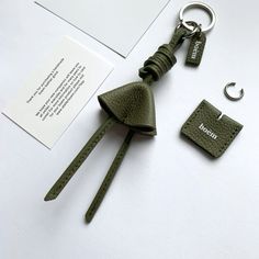 a keychain with a bell on it sitting next to a card and wallet