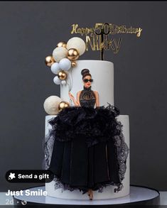 a birthday cake decorated with an image of a woman in black dress and gold balloons