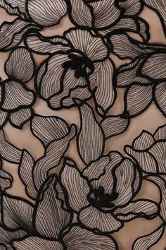 black and white floral lace fabric with large flowers on it's side, close up