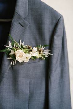 a man wearing a suit and flower boutonniere on his lapel pin