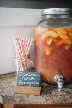 a jar filled with liquid sitting on top of a counter next to a chalkboard