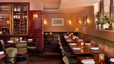 an empty restaurant with many tables and chairs in front of wine bottles on the wall