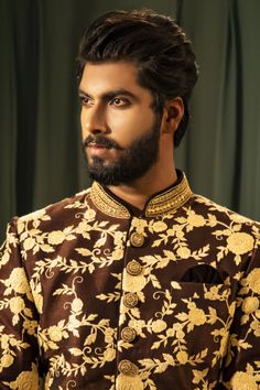 a man with a beard wearing a brown and gold shirt